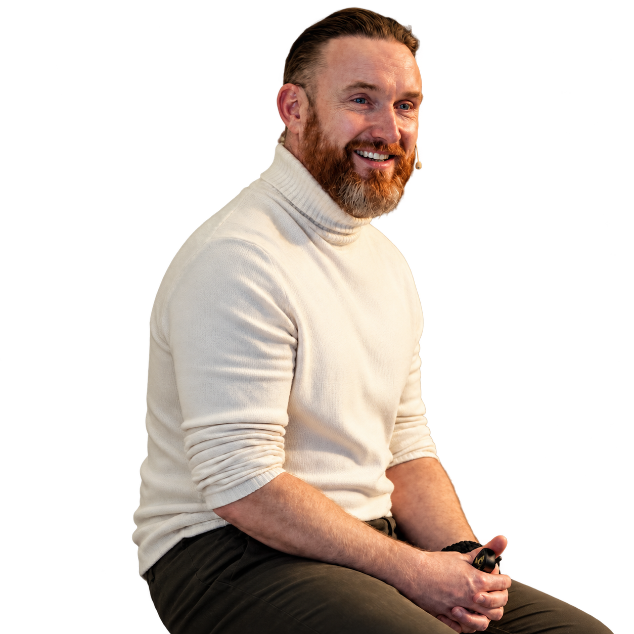 David JP Phillips smiling, seated in a cream jumper.