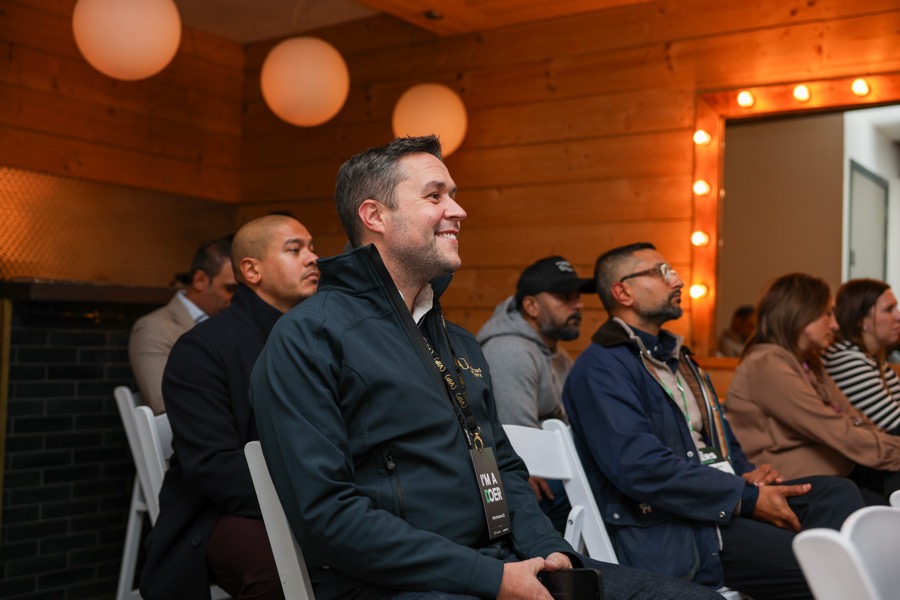 A smiling delegate listening at For the Doers 2026.